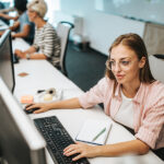 Smiling female programmer working on computer software in the office.